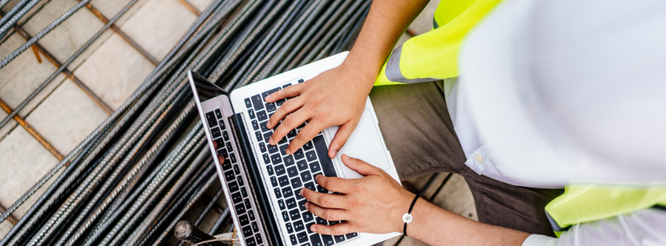 A construction worker reviewing a safety checklist on a tablet at a job site, emphasizing the importance of near-miss reporting in workplace safety management.