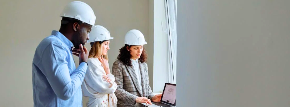 A construction worker wearing a safety helmet and vest reviews compliance documents on a laptop or tablet, representing workplace safety and COR certification requirements.